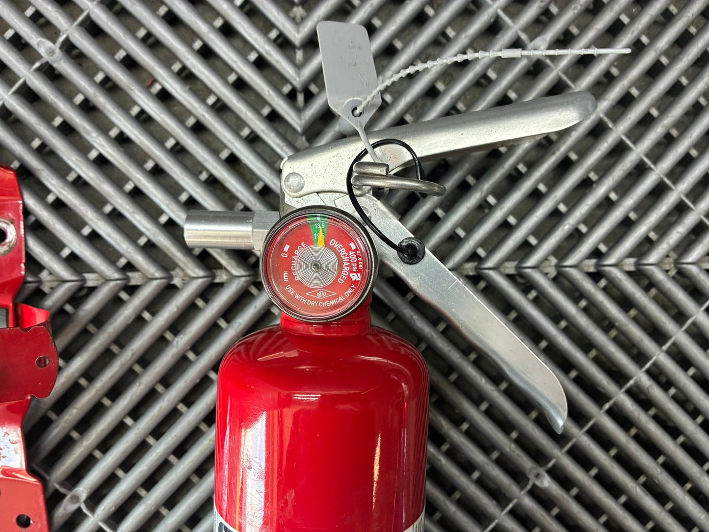 Used. Never released. Hand Fire extinguisher. Metal mounting plate.
